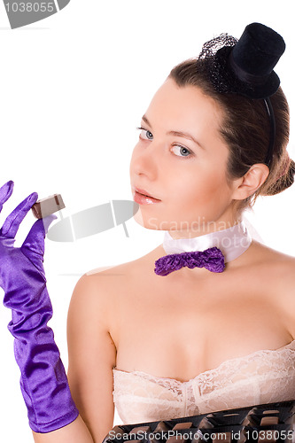 Image of attractive woman in corset and little hat eating sweets