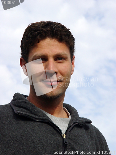 Image of Young man against the blue sky