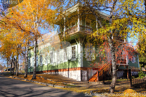 Image of wooden house between autumn trees