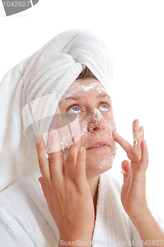 Image of woman putting cream on her face