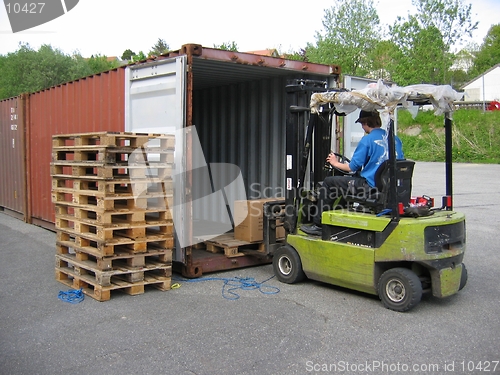 Image of Man unloading pallet with truck