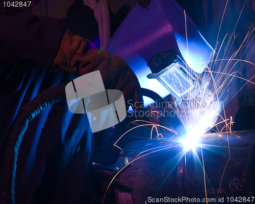 Image of Dramatic blue-lit MIG welding close