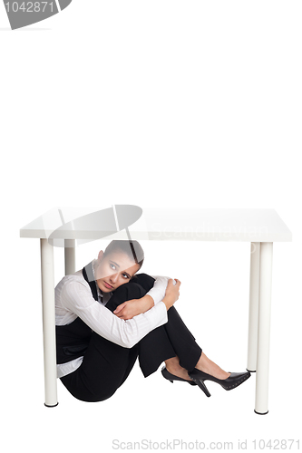 Image of Depressed business woman hiding under a table