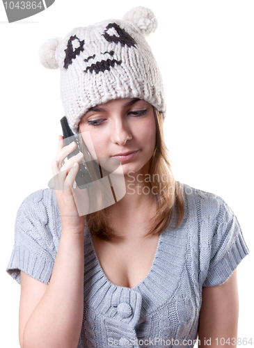 Image of Beautiful girl in winter hat with telephone