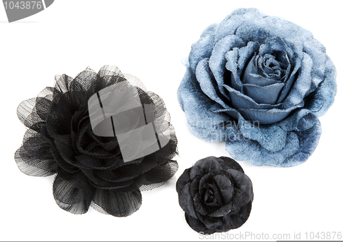 Image of Two black and one blue flower rose from lace
