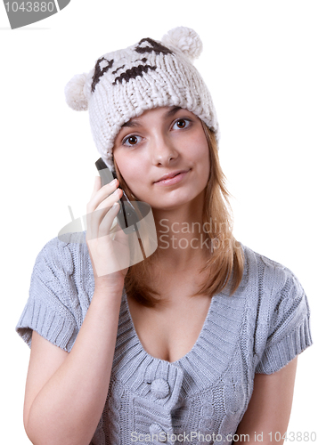 Image of Beautiful girl in winter hat with telephone