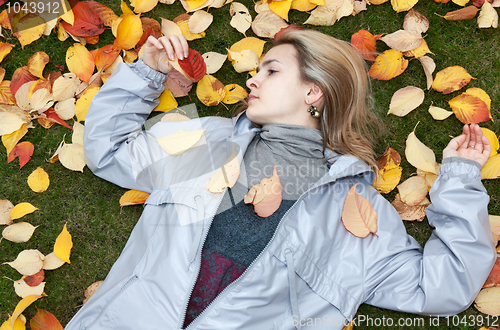 Image of Beautiful girl rests upon autumn sheet