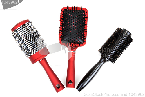 Image of Three red massages comb on white background