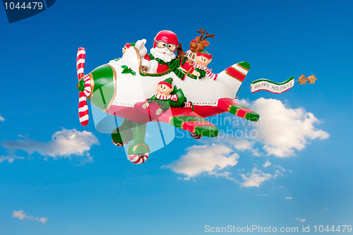 Image of Flying Santa Claus with Elves in Airplane
