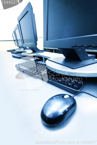 Image of workplace room with computers in row 