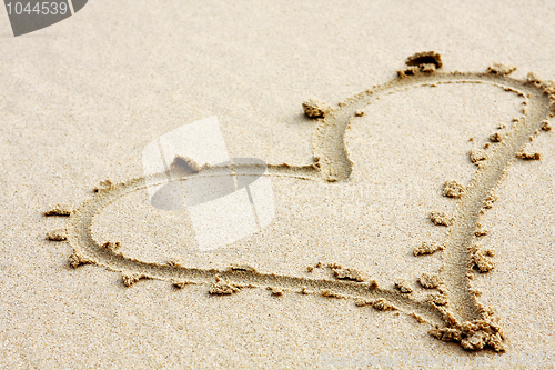 Image of hearts drawn in the sand with seafoam and wave