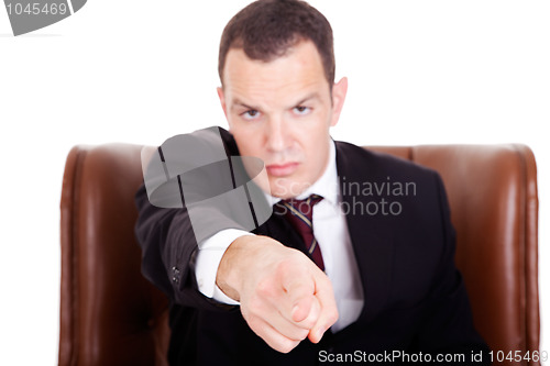 Image of Angry businessman seated on a chair, pointing