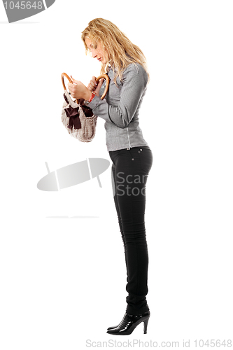 Image of Young blonde looks in her handbag