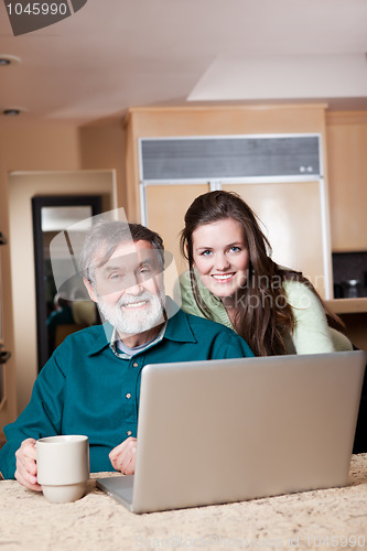 Image of Teenage girl with grandpa using laptop