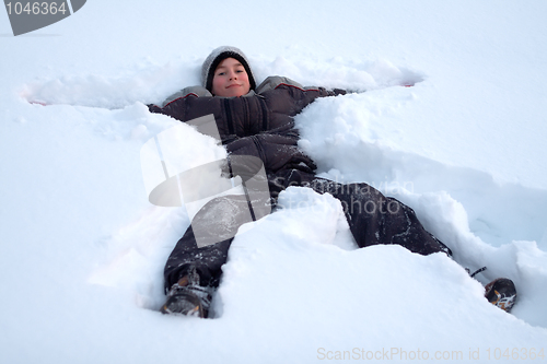 Image of Happy Boy Laying In Fresh Snow