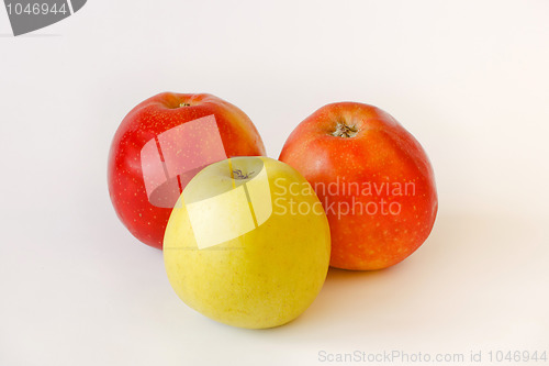 Image of two red and one green apples on white background