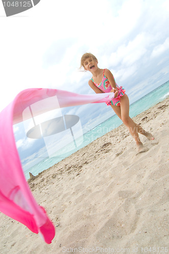 Image of child playing with a cloth at the beach
