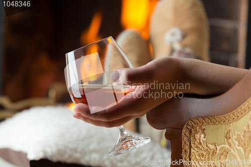 Image of Resting at the burning fireplace fire with a glass of cognac