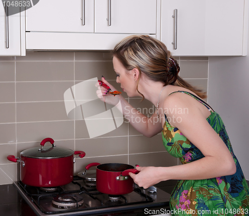 Image of young woman cooking dinner