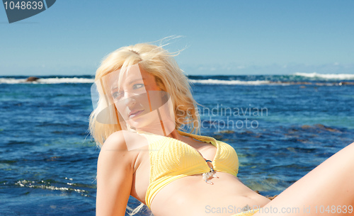 Image of young woman on reef at sea