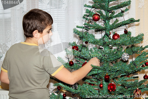 Image of Young boy holding Christmas decorations