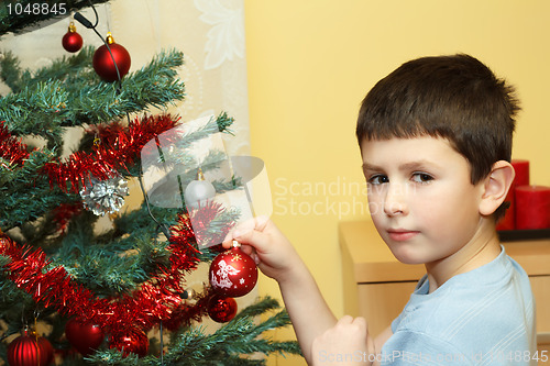 Image of Young boy holding Christmas decorations