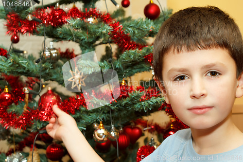 Image of Young boy holding Christmas decorations