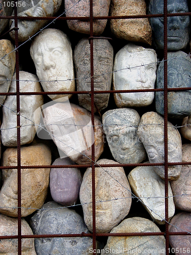Image of Stone faces behind the bars