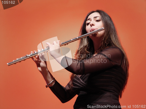 Image of Beautiful girl playing flute at the concert