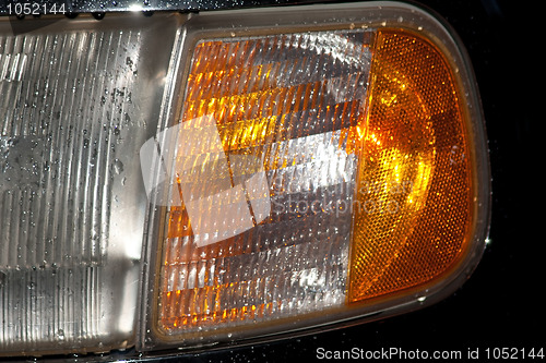 Image of headlight by rain with water splash