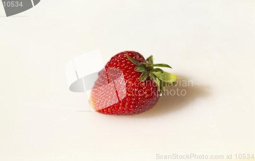 Image of A sunlit solitary strawberry rests on a white cutting board (Macro, 14MP camera)