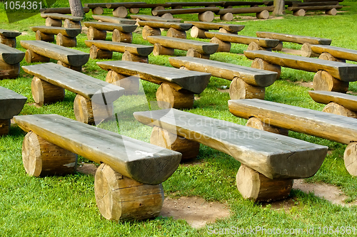 Image of outdoor wood seating on green lawn