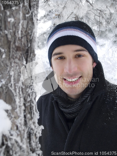 Image of young man smiling in winter park 