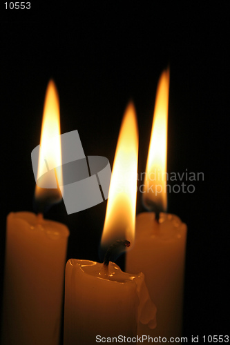 Image of Three candles burning in the dark