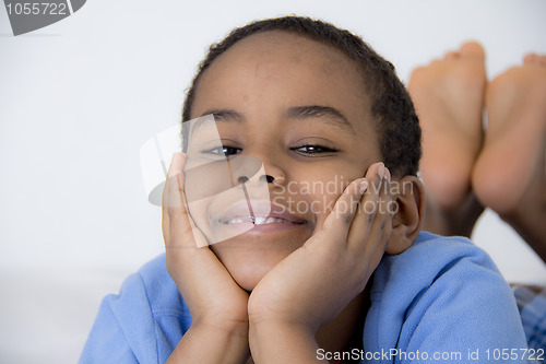Image of Young kid with his face resting on his hands