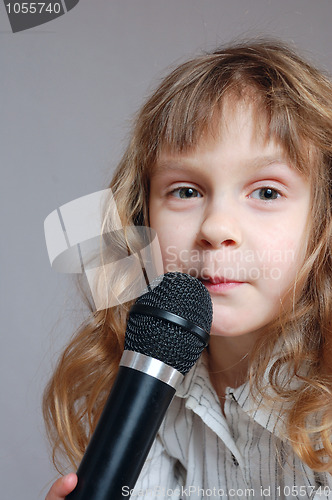 Image of Cute little girl with black microphone.