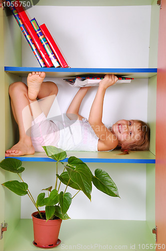 Image of child reading a book in a bookcase