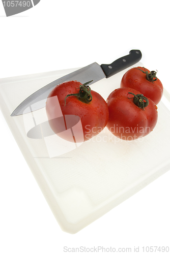 Image of Cutting board with a knife and tomato