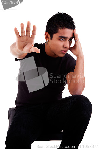 Image of young latin man, pensive, with his hand in stop signal