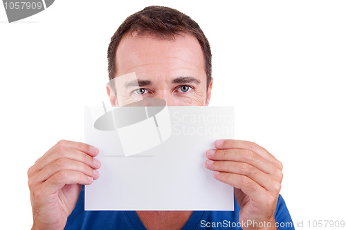 Image of Man holding a white card in front of face, looking to camera