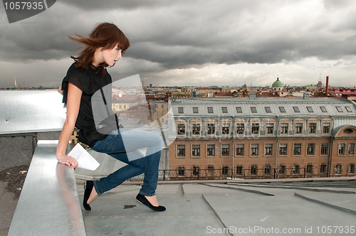 Image of Dramatic girl with letter walking a roof