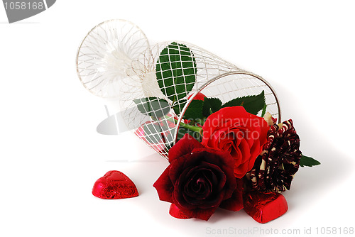 Image of Three different red tint roses in mesh vase and chocolate candies