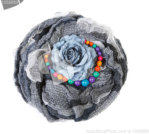 Image of Varicoloured scarf is put with necklace around and flower