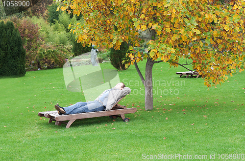 Image of A man, lying on a lounger