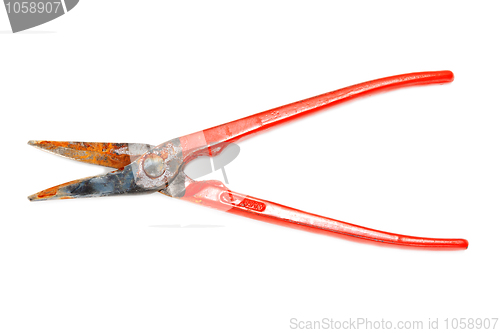 Image of Rusty scissors on metal with red handle