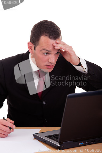 Image of businessman  surprised and worried looking to computer