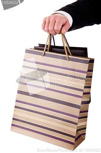 Image of detail of a hand of a man doing shopping,with bags 