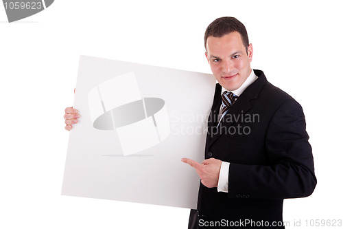 Image of handsome businessman holding a whiteboard and pointing, looking at the camera and smiling