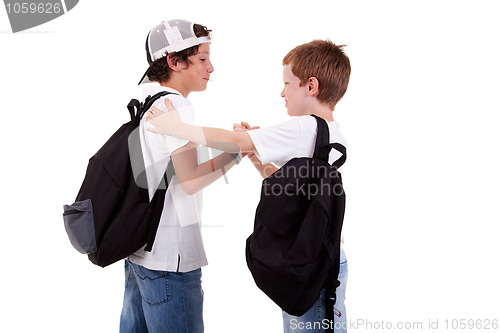 Image of boys going to school, greeting one another, seen from the back