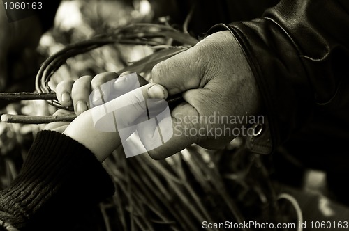 Image of Man teaching child making a wicker basket